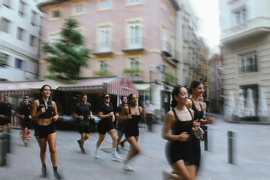 El grupo de la Social Run corriendo por una calle del centro de Murcia, con las fachadas movidas por la velocidad