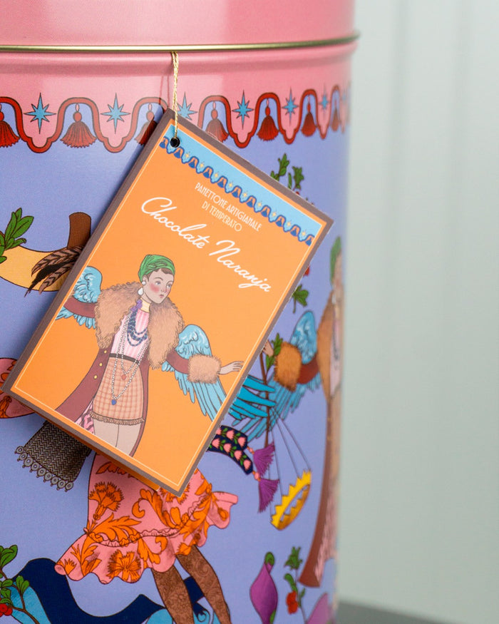 Lata de colección lila con la etiqueta colgante del panettone de chocolate y naranja y su ángel ilustrado