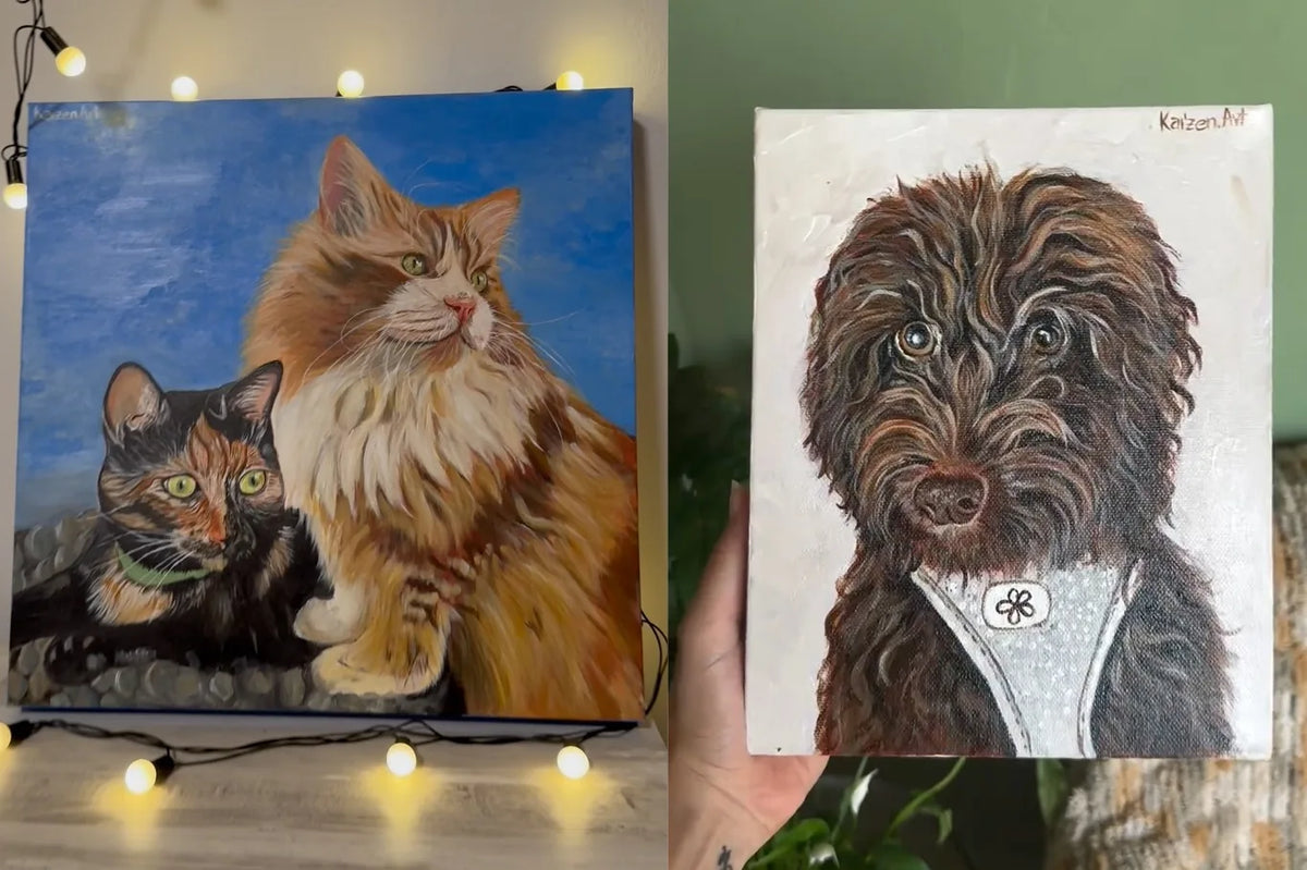 A la izquierda, un lienzo con dos gatos —uno naranja de pelo largo y otro tricolor— sobre fondo azul, apoyado entre una guirnalda de bombillas; a la derecha, una mano sostiene el retrato de un perro de agua marrón con pañuelo blanco. Los dos firmados «Kaizen.Art»