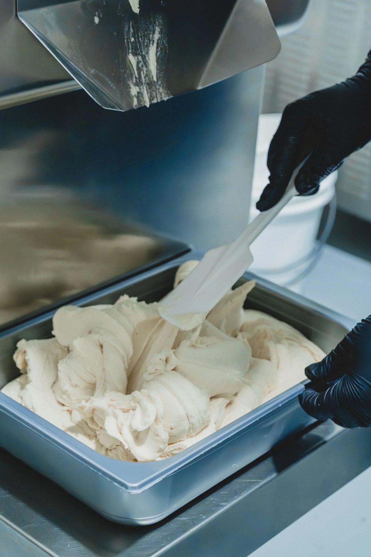 Alisando a mano el gelato para perros en su vasqueta, en el obrador de Totana