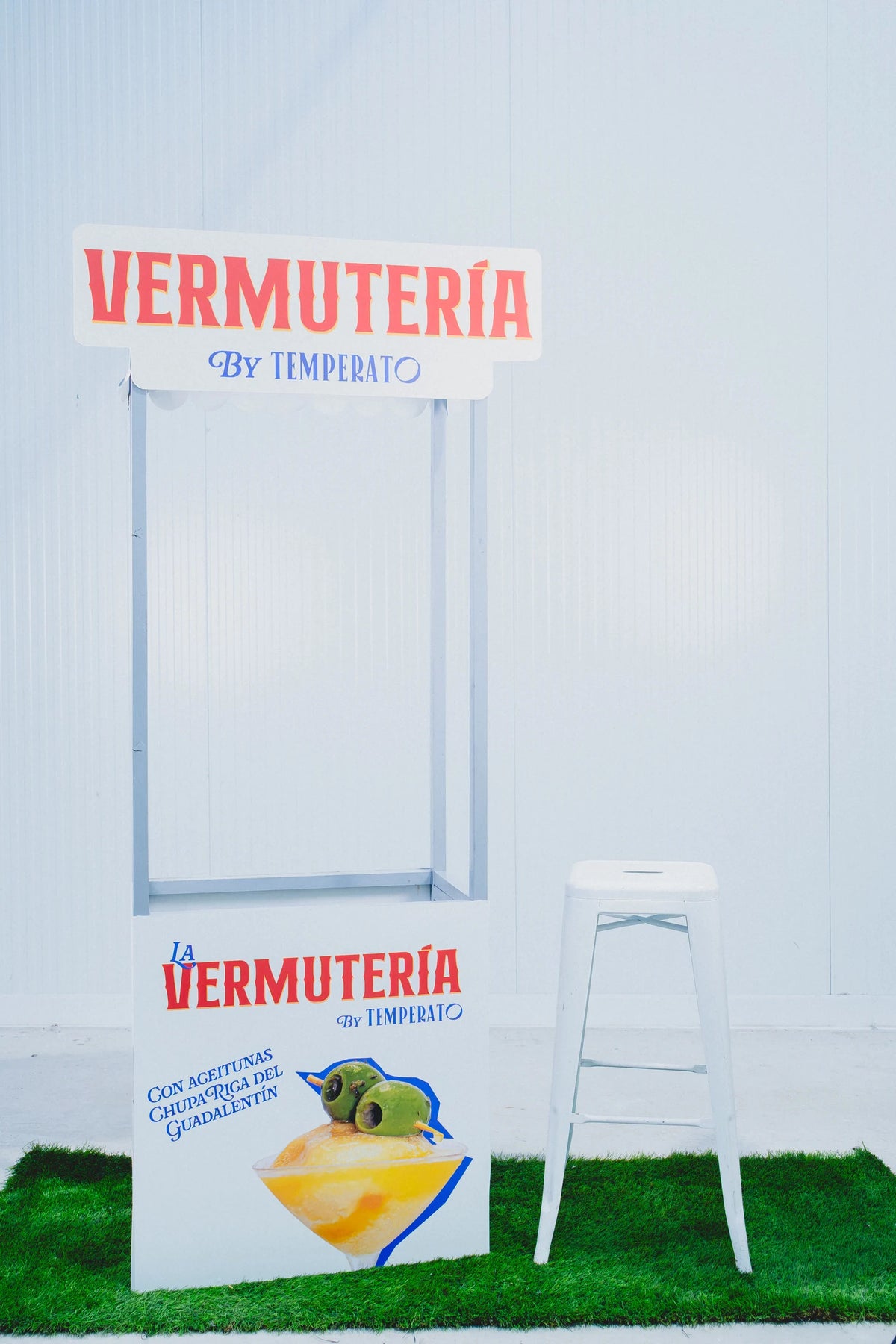 El carrito de La Vermutería de Temperato, con su rótulo y su cartel, montado sobre césped