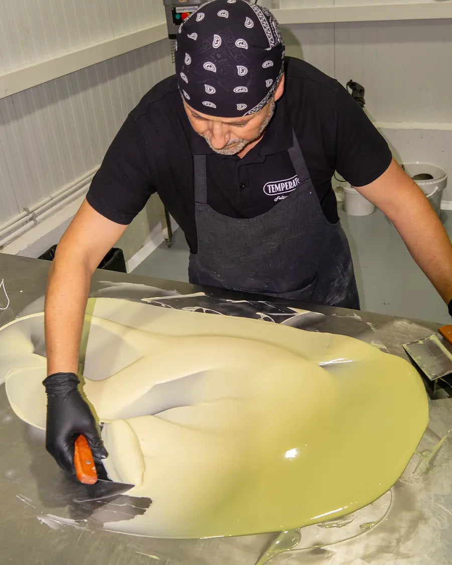 El pastelero atemperando a mano el chocolate blanco